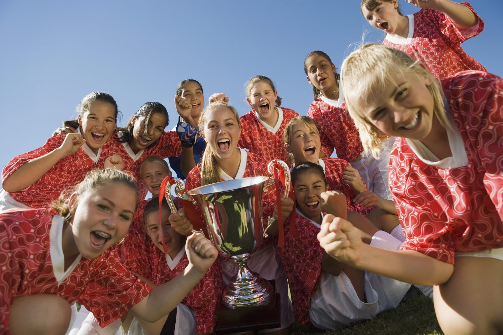 A youth team celebrating with a trophy