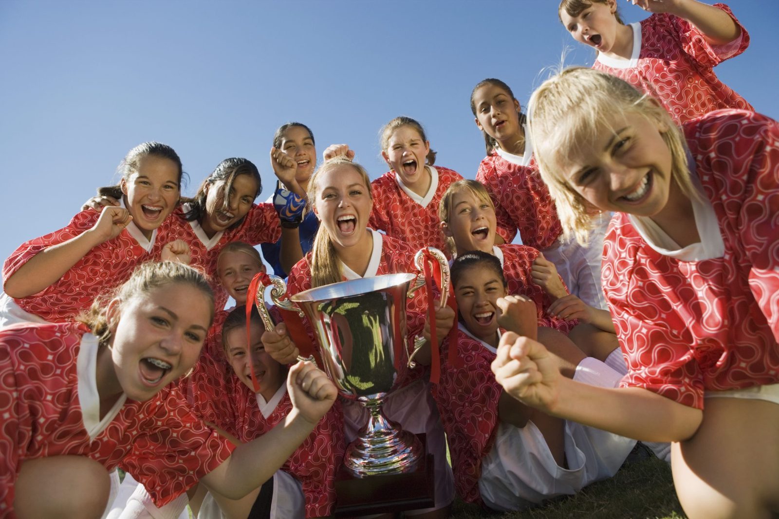 A youth team celebrating with a trophy